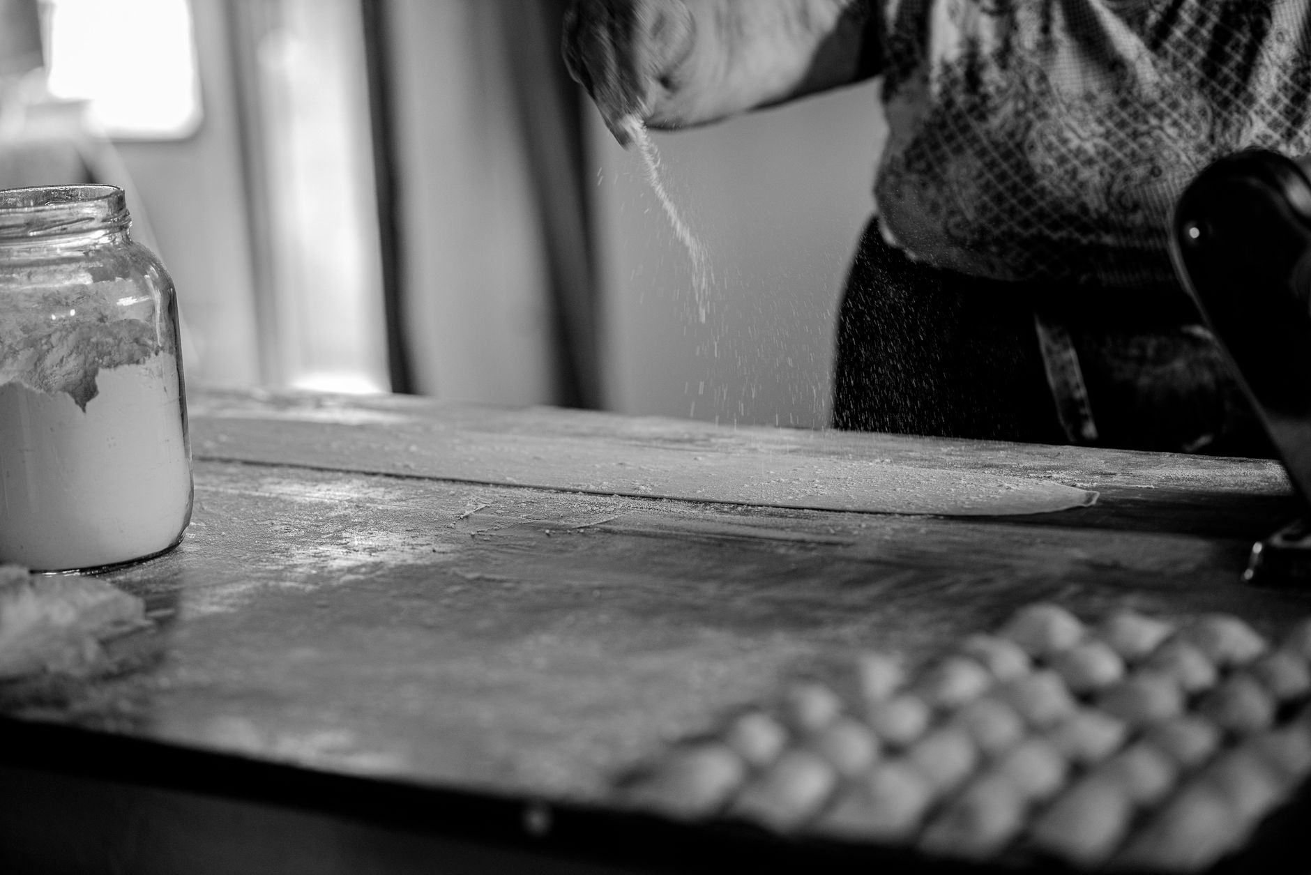 Artisan preparing handcrafted pasta by rustic window